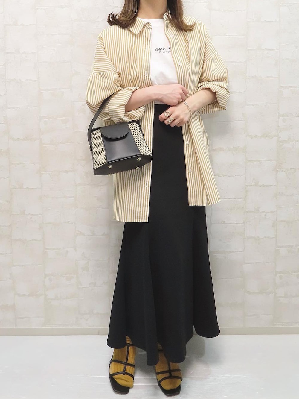 ブラック系のサンダル、イエロー系のシャツ/ブラウス、ホワイト系のTシャツ/カットソーを着用したレディースの春コーディネートの3枚目の写真