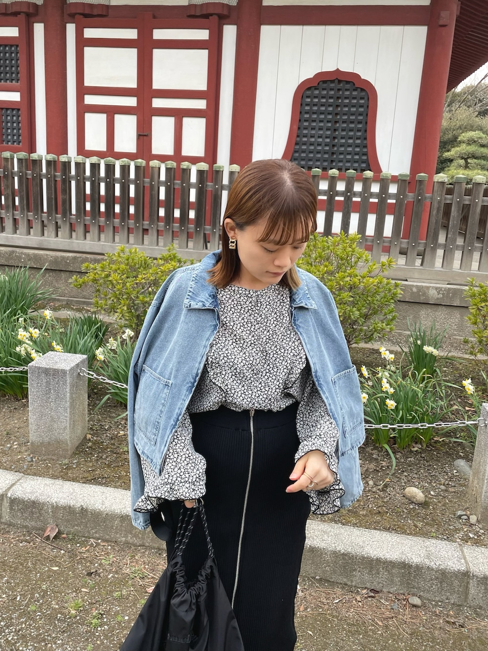 ブラック系のシャツ/ブラウス、ブルー系のデニムジャケット、ブラック系のスカートを着用したレディースの春コーディネートの2枚目の写真