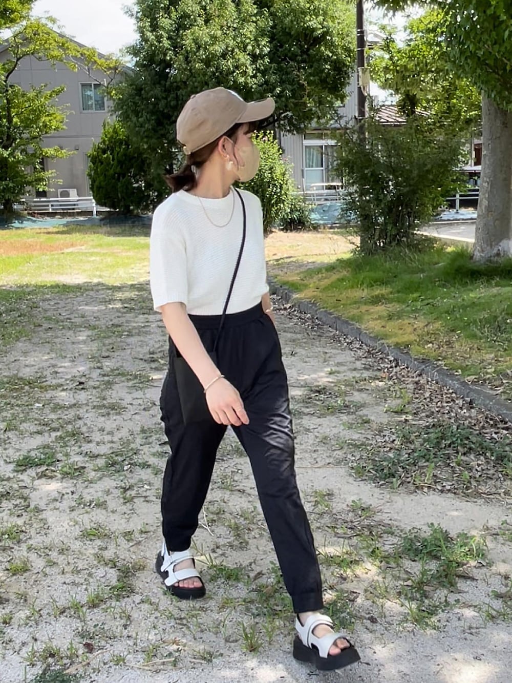 ホワイト系のニット/セーター、ブラック系のその他パンツ、ブラック系のショルダーバッグを着用したレディースの夏コーディネートの3枚目の写真