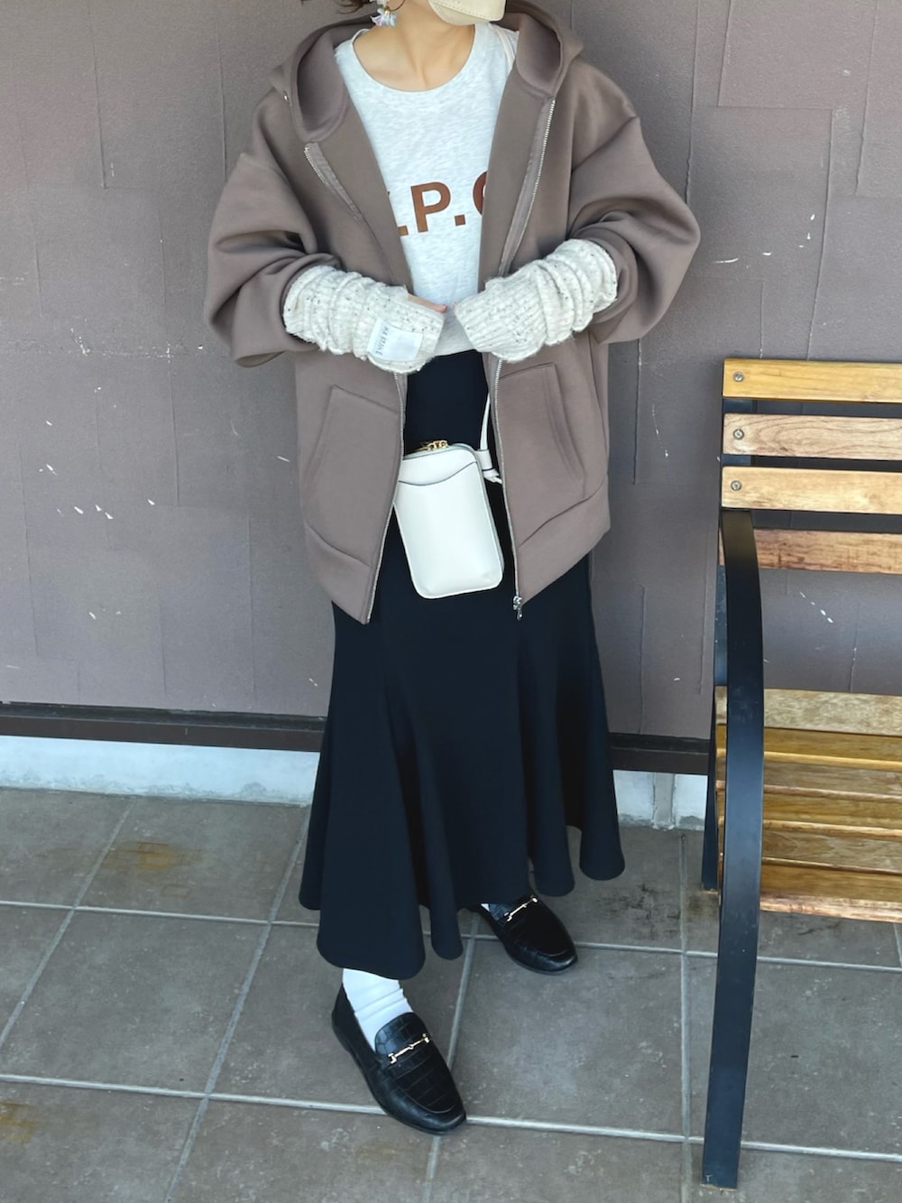 ブラウン系のパーカー、ブラック系のスカート、ホワイト系のTシャツ/カットソーを着用したレディースの秋コーディネートの4枚目の写真