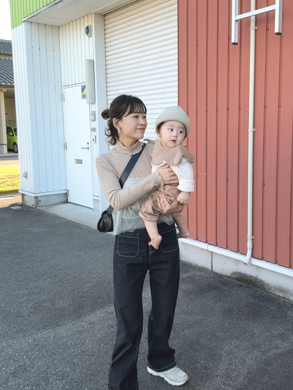 ベージュ系のTシャツ/カットソー、ブラック系のデニムパンツ、ブラック系のショルダーバッグを着用したレディースの秋コーディネートの4枚目の写真