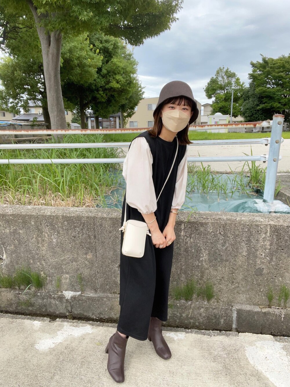 ブラック系のワンピース、ブラウン系のブーツ、ブラウン系のハットを着用したレディースの秋コーディネートの4枚目の写真