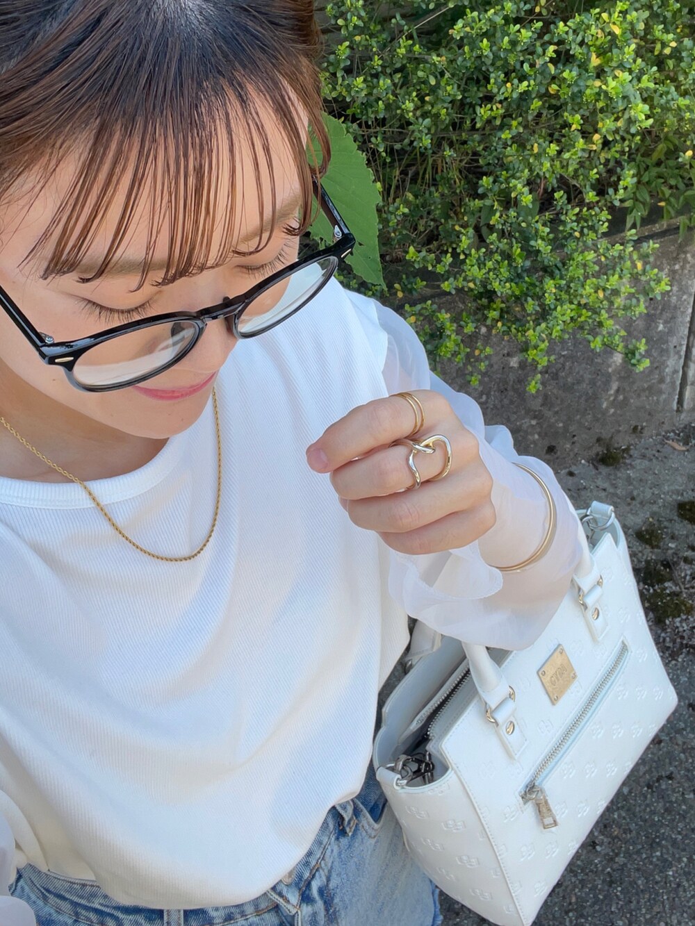 ホワイト系のハンドバッグ、ホワイト系のTシャツ/カットソー、その他のデニムパンツを着用したレディースの春コーディネートの5枚目の写真