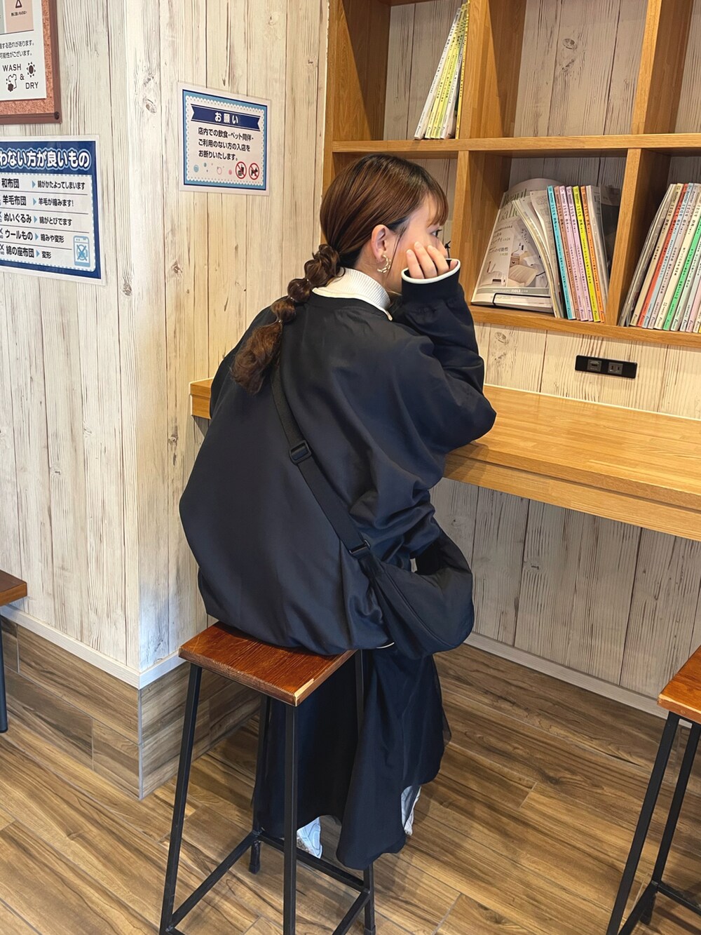 ブラック系のスウェット、ブラック系のスカート、ブラック系のショルダーバッグを着用したレディースの春コーディネートの3枚目の写真