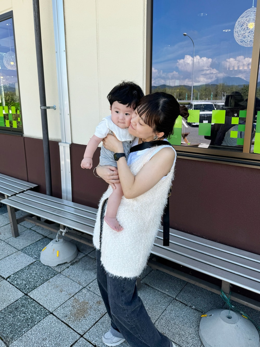 ホワイト系のベスト、ブラック系のショルダーバッグ、ブラック系のデニムパンツを着用したレディースの秋コーディネートの2枚目の写真