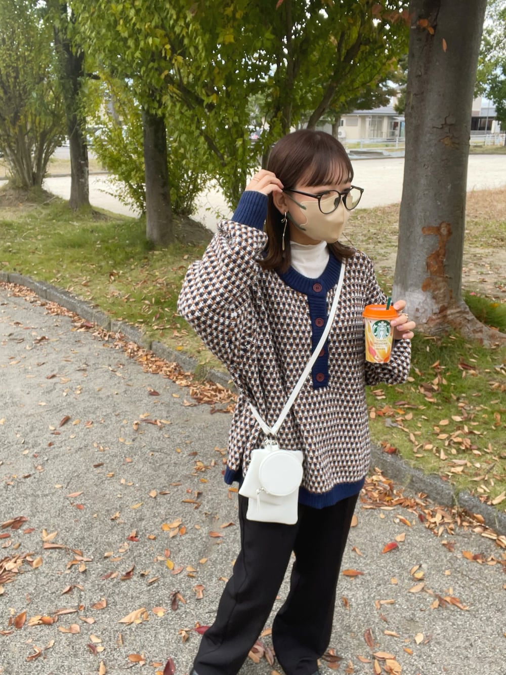 ブルー系のニット/セーター、ホワイト系のTシャツ/カットソー、ホワイト系のショルダーバッグを着用したレディースの秋コーディネートの4枚目の写真