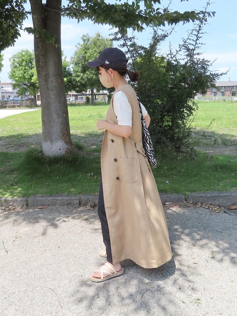 ベージュ系のベスト、ホワイト系のニット/セーター、ブラック系のその他パンツを着用したレディースの夏コーディネートの2枚目の写真