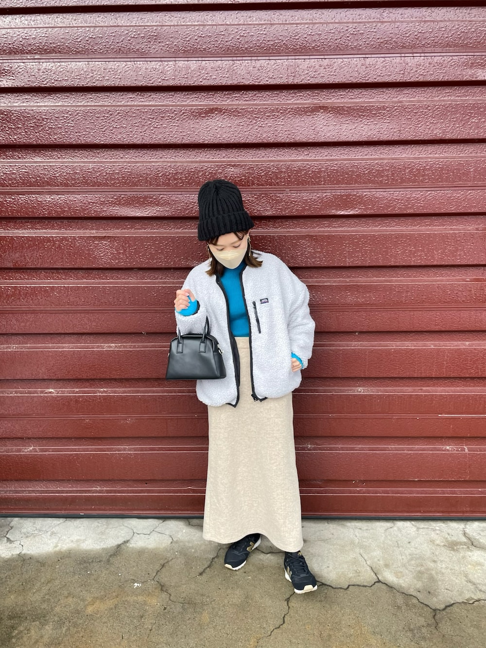 ベージュ系のブルゾン、ブルー系のニット/セーター、ベージュ系のスカートを着用したレディースの冬コーディネートの2枚目の写真