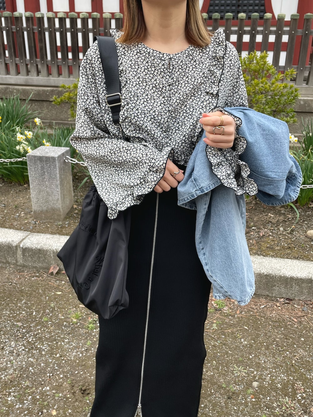 ブラック系のシャツ/ブラウス、ブルー系のデニムジャケット、ブラック系のスカートを着用したレディースの春コーディネートの3枚目の写真