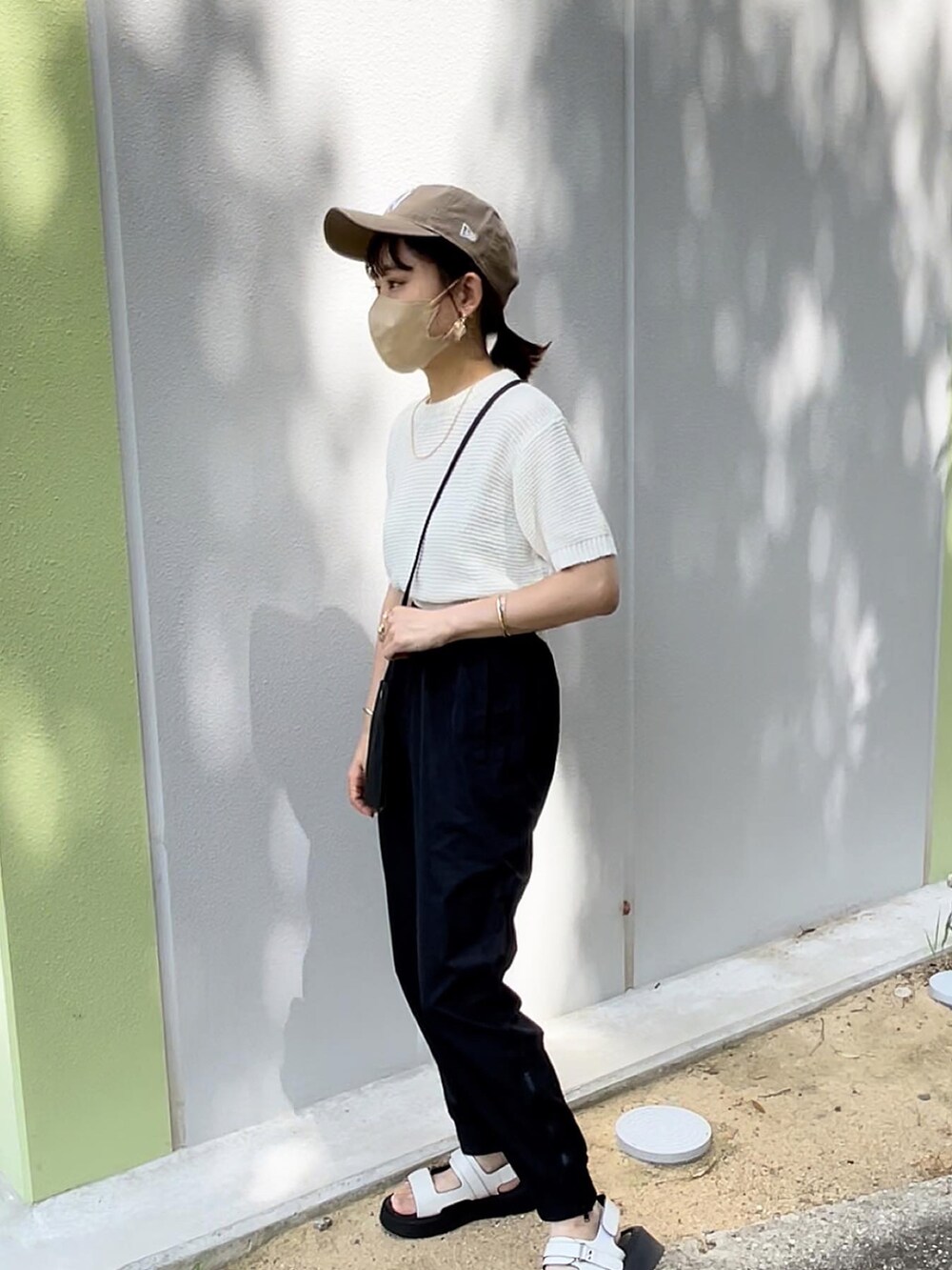 ホワイト系のニット/セーター、ブラック系のその他パンツ、ブラック系のショルダーバッグを着用したレディースの夏コーディネートの4枚目の写真