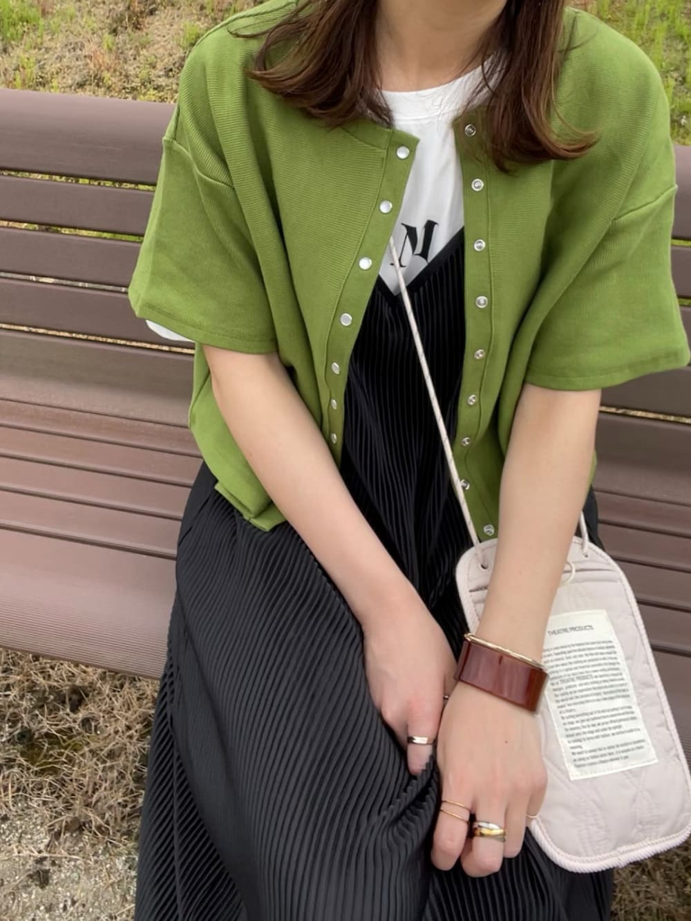 グリーン系のカーディガン/ボレロ、ホワイト系のTシャツ/カットソー、ブラック系のワンピース/ドレスを着用したレディースの春コーディネートの3枚目の写真