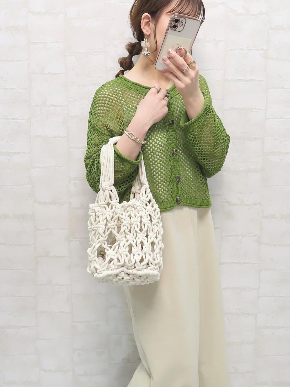 グリーン系のトップス、ホワイト系のハンドバッグ、ベージュ系のワンピース/ドレスを着用したレディースの春コーディネートの3枚目の写真