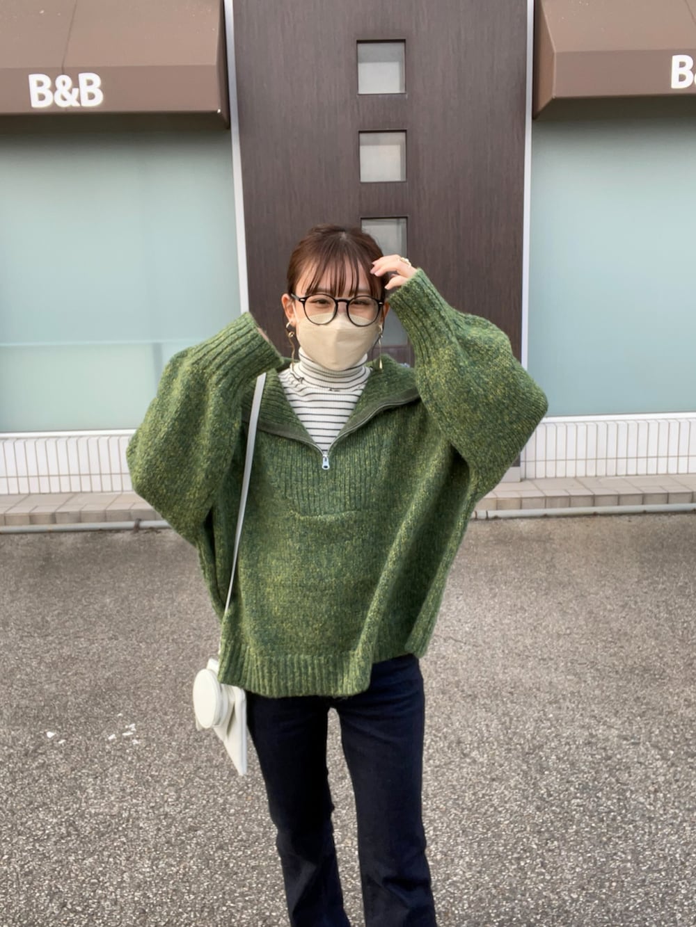 グリーン系のニット/セーター、ホワイト系のニット/セーター、ブルー系のデニムパンツを着用したレディースの秋コーディネートの2枚目の写真