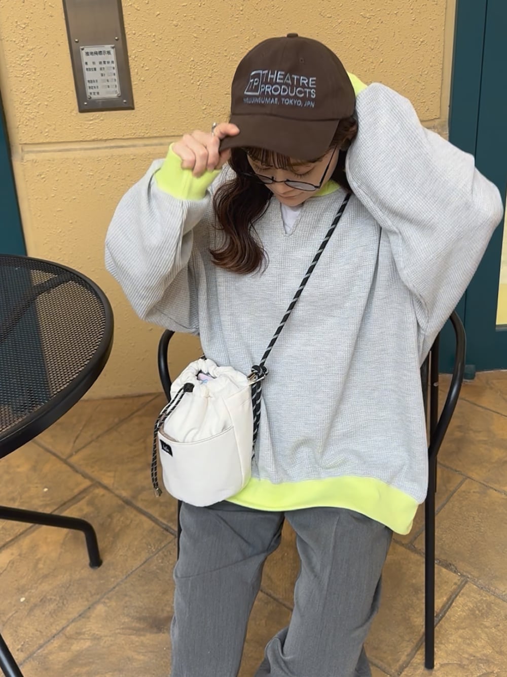 グレー系のTシャツ/カットソー、ベージュ系のスニーカー、グレー系のパンツを着用したレディースの春コーディネートの2枚目の写真