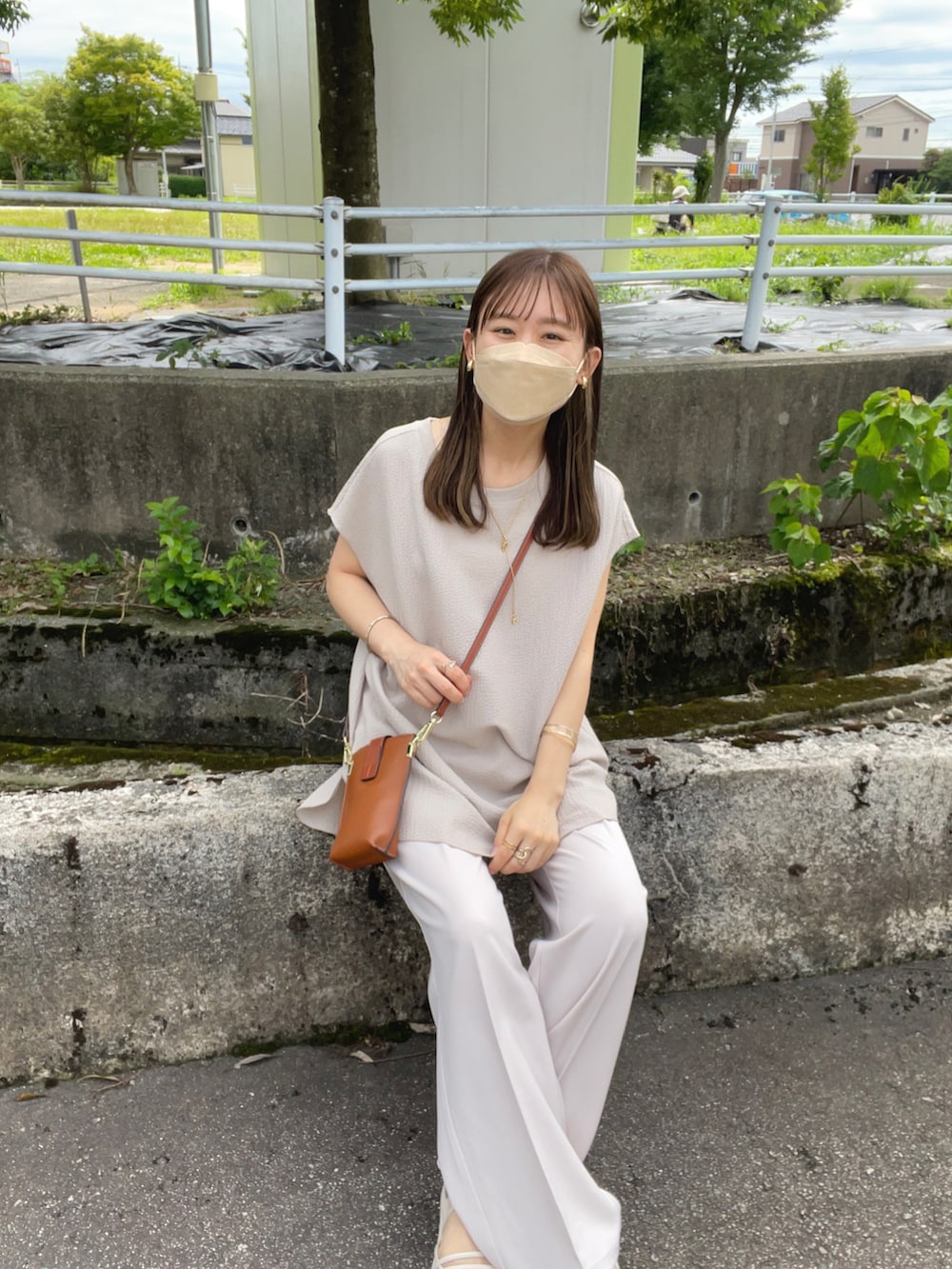 ベージュ系のTシャツ/カットソー、ホワイト系のその他パンツ、ブラウン系のショルダーバッグを着用したレディースの夏コーディネートの2枚目の写真