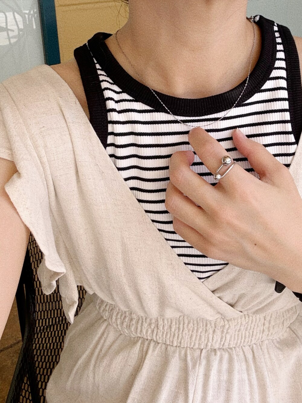 ホワイト系のオールインワン・サロペット、ブラック系のショルダーバッグ、ホワイト系のタンクトップを着用したレディースの夏コーディネートの3枚目の写真