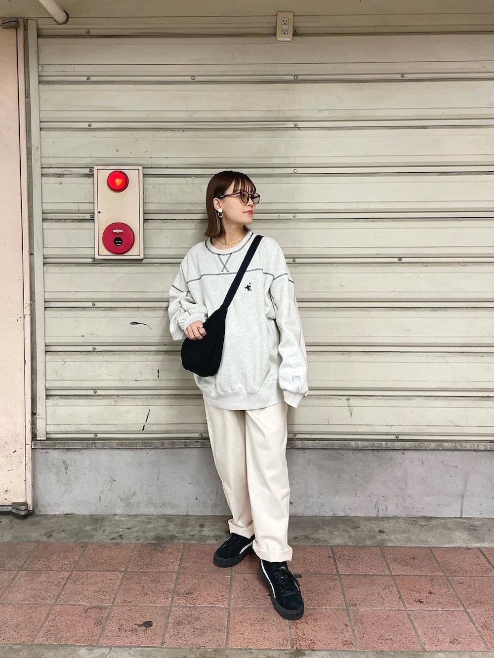 ベージュ系のスウェット、ベージュ系のデニムパンツ、ブラック系のショルダーバッグを着用したレディースの秋コーディネートの4枚目の写真