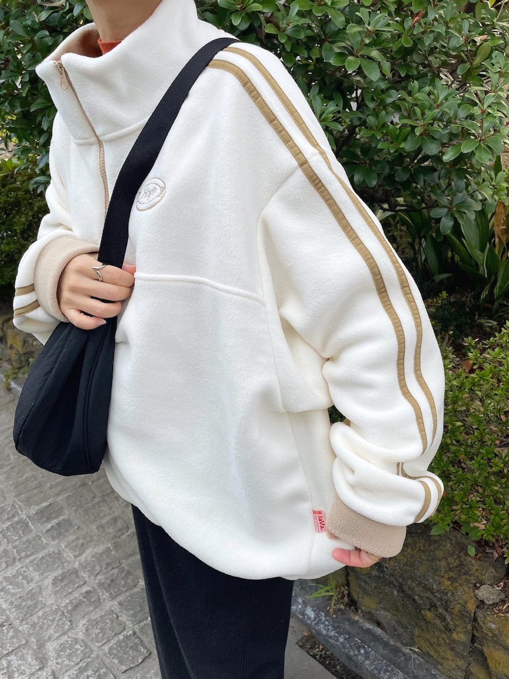 ホワイト系のスウェット、ブラウン系のニット/セーター、ブラック系のショルダーバッグを着用したレディースの秋コーディネートの5枚目の写真