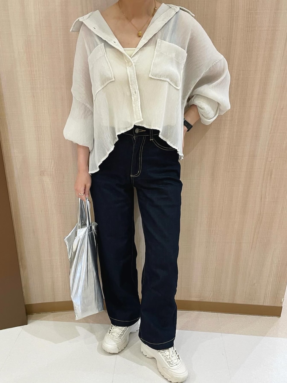 ブルー系のパンツ、ホワイト系のシャツ/ブラウス、シルバー系のトートバッグを着用したレディースの春コーディネートの4枚目の写真