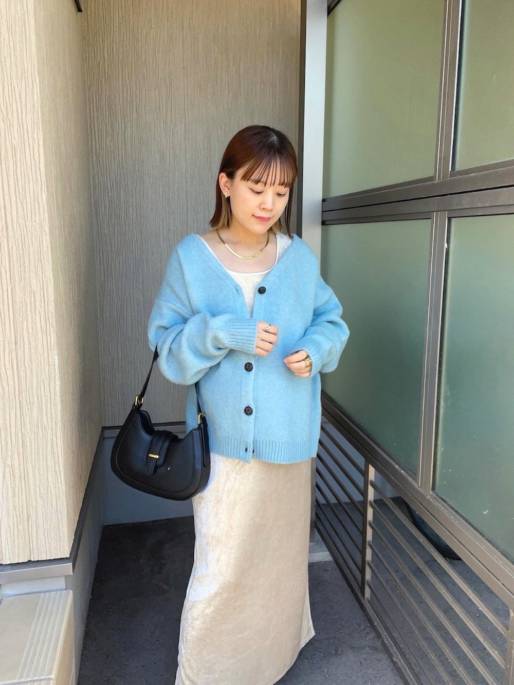 ブルー系のカーディガン/ボレロ、ホワイト系のワンピース、ブラック系のバッグを着用したレディースの秋コーディネートの4枚目の写真