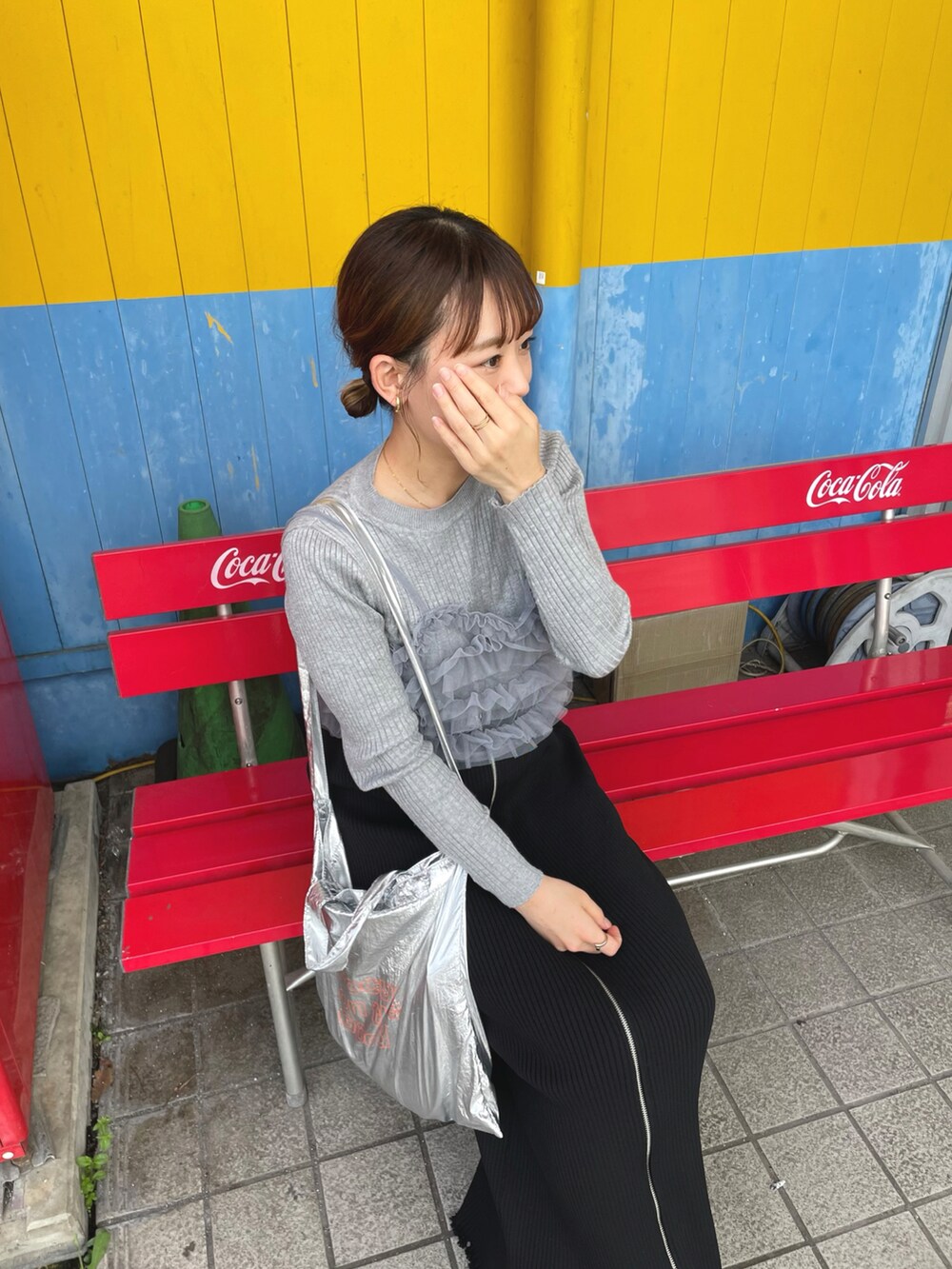 シルバー系のトップス、グレー系のトップス、ブラック系のスカートを着用したレディースの夏コーディネートの3枚目の写真