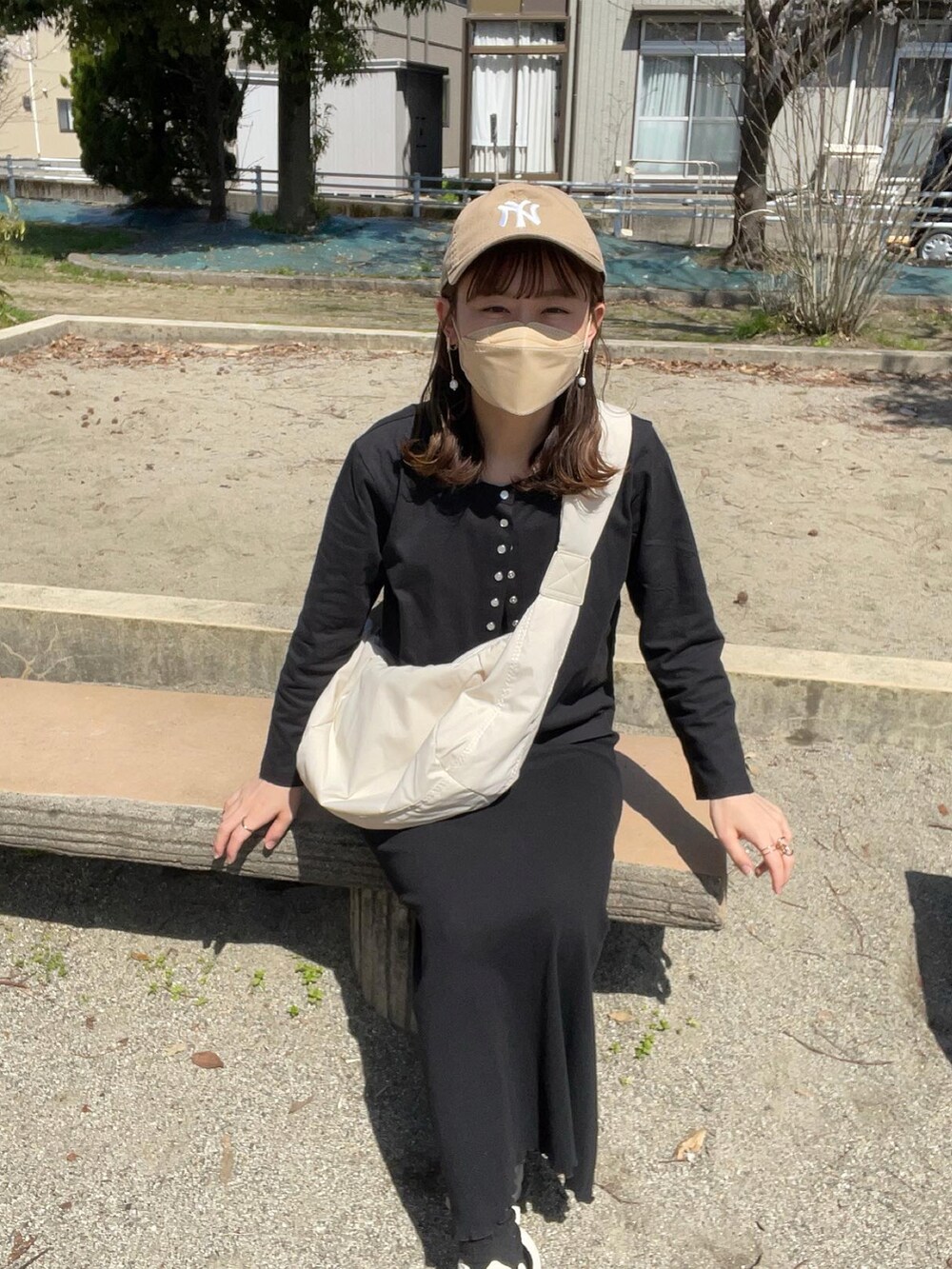 ブラック系のカーディガン/ボレロ、ブラック系のワンピース、ホワイト系のショルダーバッグを着用したレディースの春コーディネートの3枚目の写真