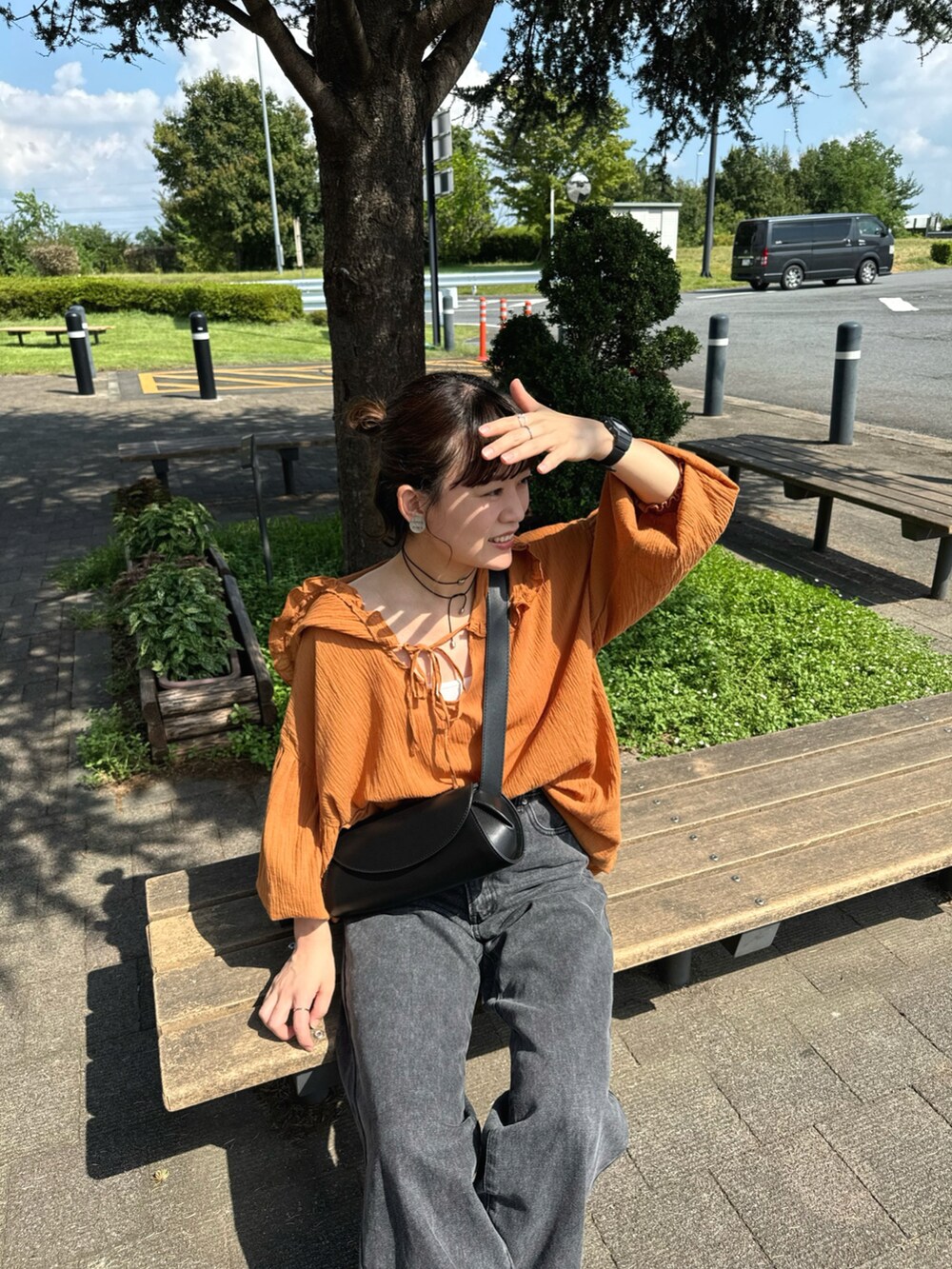 ブラウン系のシャツ/ブラウス、ブラック系のデニムパンツ、ブラック系のショルダーバッグを着用したレディースの秋コーディネートの3枚目の写真