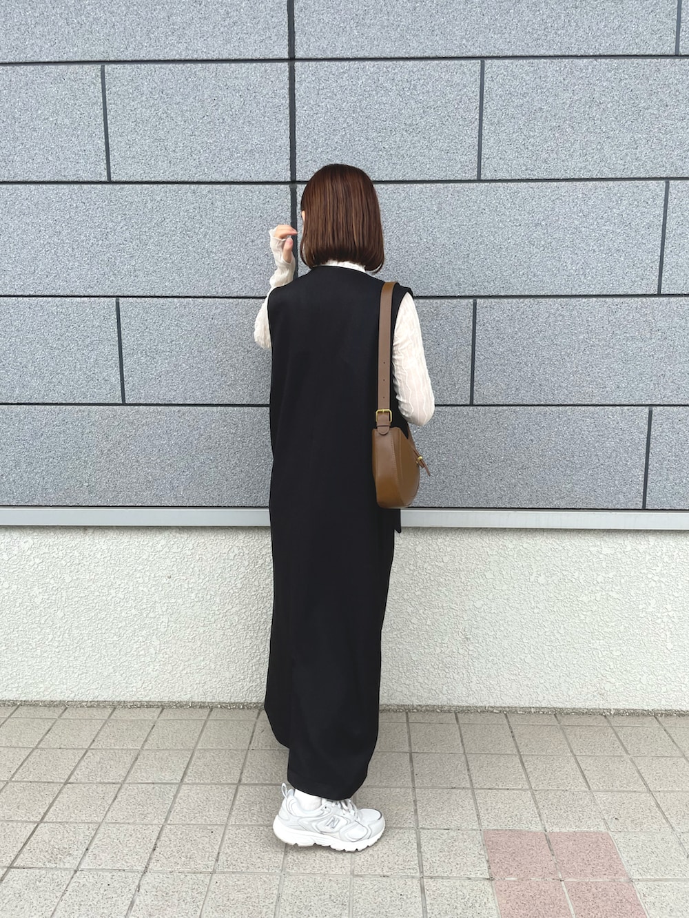 ブラック系のワンピース、ホワイト系のTシャツ/カットソー、ブラウン系のバッグを着用したレディースの夏コーディネートの2枚目の写真
