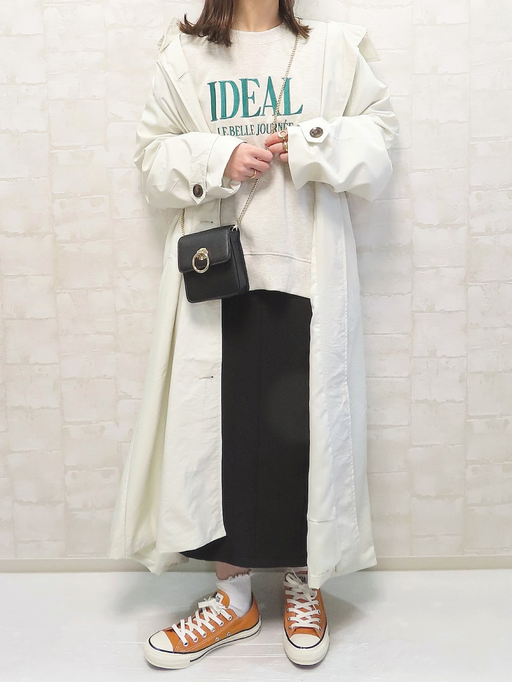 ホワイト系のトレンチコート、その他のスウェット、ブラック系のショルダーバッグを着用したレディースの春コーディネートの3枚目の写真