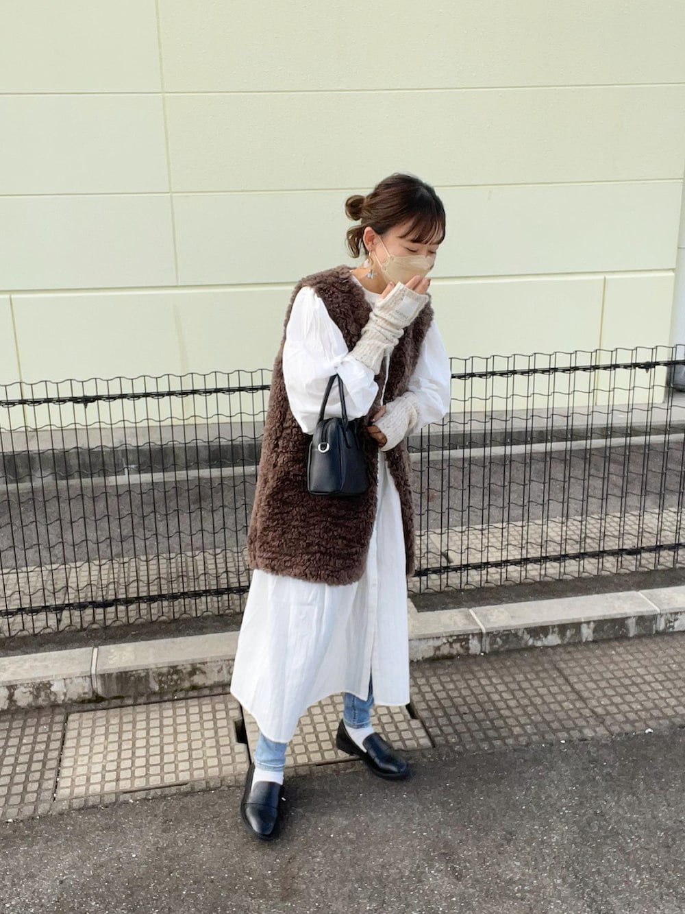 ホワイト系のシャツワンピース、ブラウン系のその他アウター、ブルー系のデニムパンツを着用したレディースの秋コーディネートの2枚目の写真