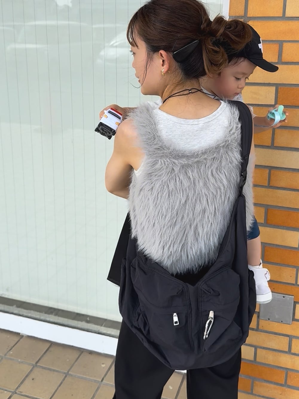 ブラック系のスウェットパンツ、ブラック系のサンダル、グレー系のベストを着用したレディースの夏コーディネートの3枚目の写真