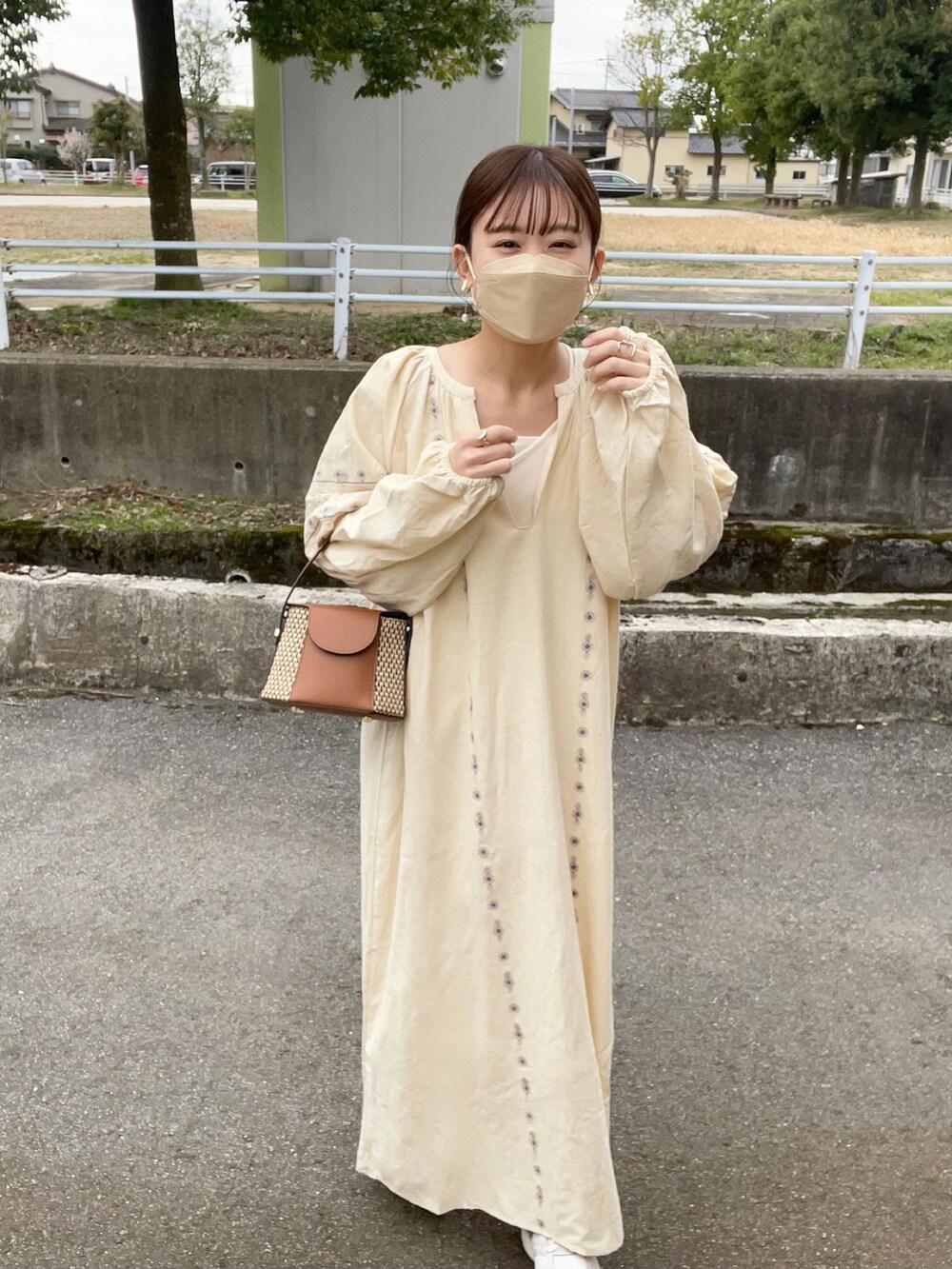 ホワイト系のワンピース、ホワイト系のキャミソール、イエロー系のショルダーバッグを着用したレディースの春コーディネートの2枚目の写真