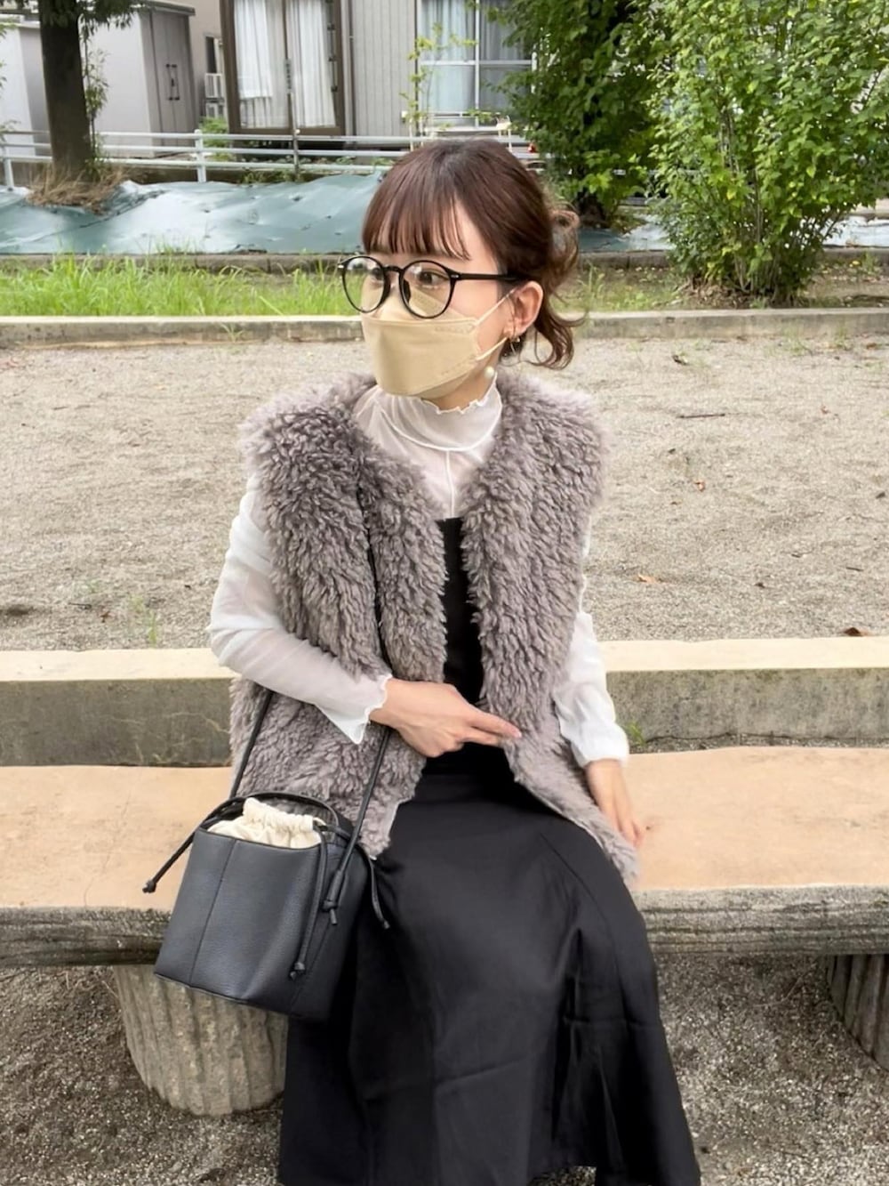 ベージュ系のベスト、ホワイト系のTシャツ/カットソー、ブラック系のジャンパースカートを着用したレディースの秋コーディネートの4枚目の写真