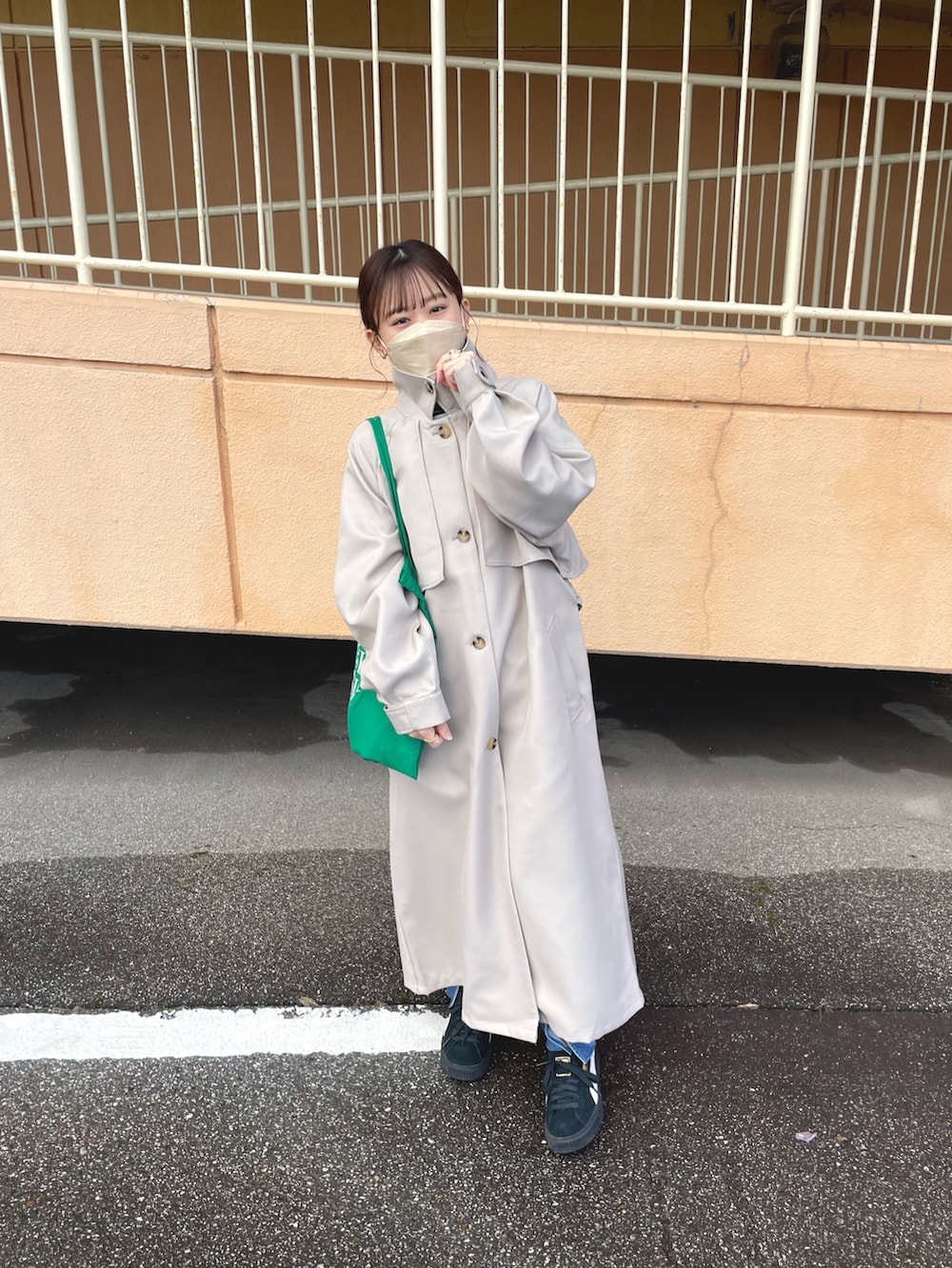 ベージュ系のトレンチコート、ホワイト系のTシャツ/カットソー、ブルー系のデニムパンツを着用したレディースの冬コーディネートの4枚目の写真