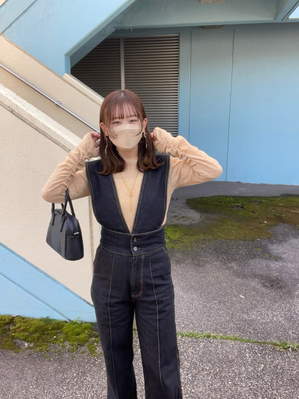 オレンジ系のTシャツ/カットソー、ブラック系のサロペット/オーバーオール、ホワイト系のスニーカーを着用したレディースの春コーディネートの3枚目の写真