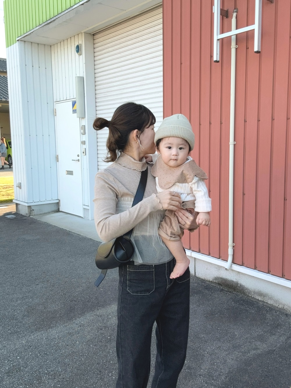 ベージュ系のTシャツ/カットソー、ブラック系のデニムパンツ、ブラック系のショルダーバッグを着用したレディースの秋コーディネートの5枚目の写真
