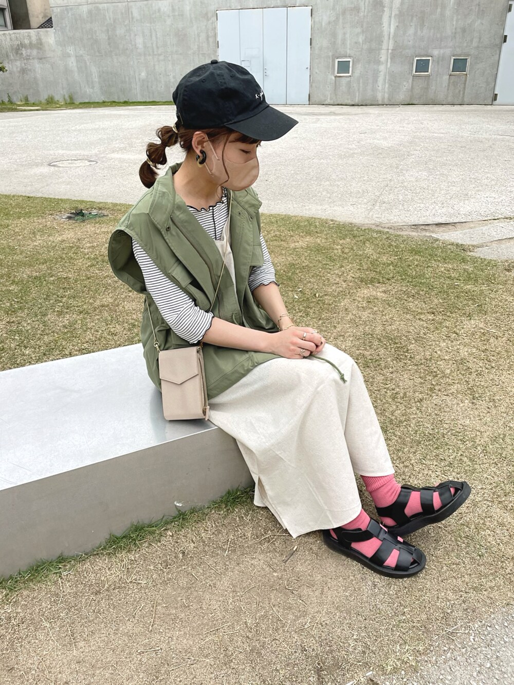 グリーン系のワンピース、ホワイト系のTシャツ/カットソー、グリーン系のベストを着用したレディースの春コーディネートの2枚目の写真