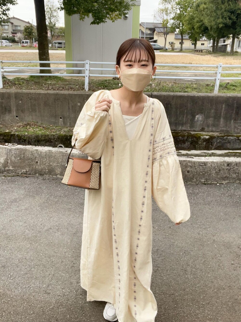 ホワイト系のワンピース、ホワイト系のキャミソール、イエロー系のショルダーバッグを着用したレディースの春コーディネートの3枚目の写真