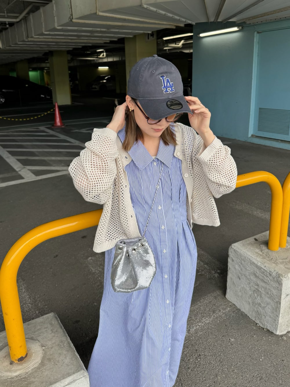 ブルー系のワンピース、ホワイト系のカーディガン/ボレロ、シルバー系のバッグを着用したレディースの春コーディネートの2枚目の写真