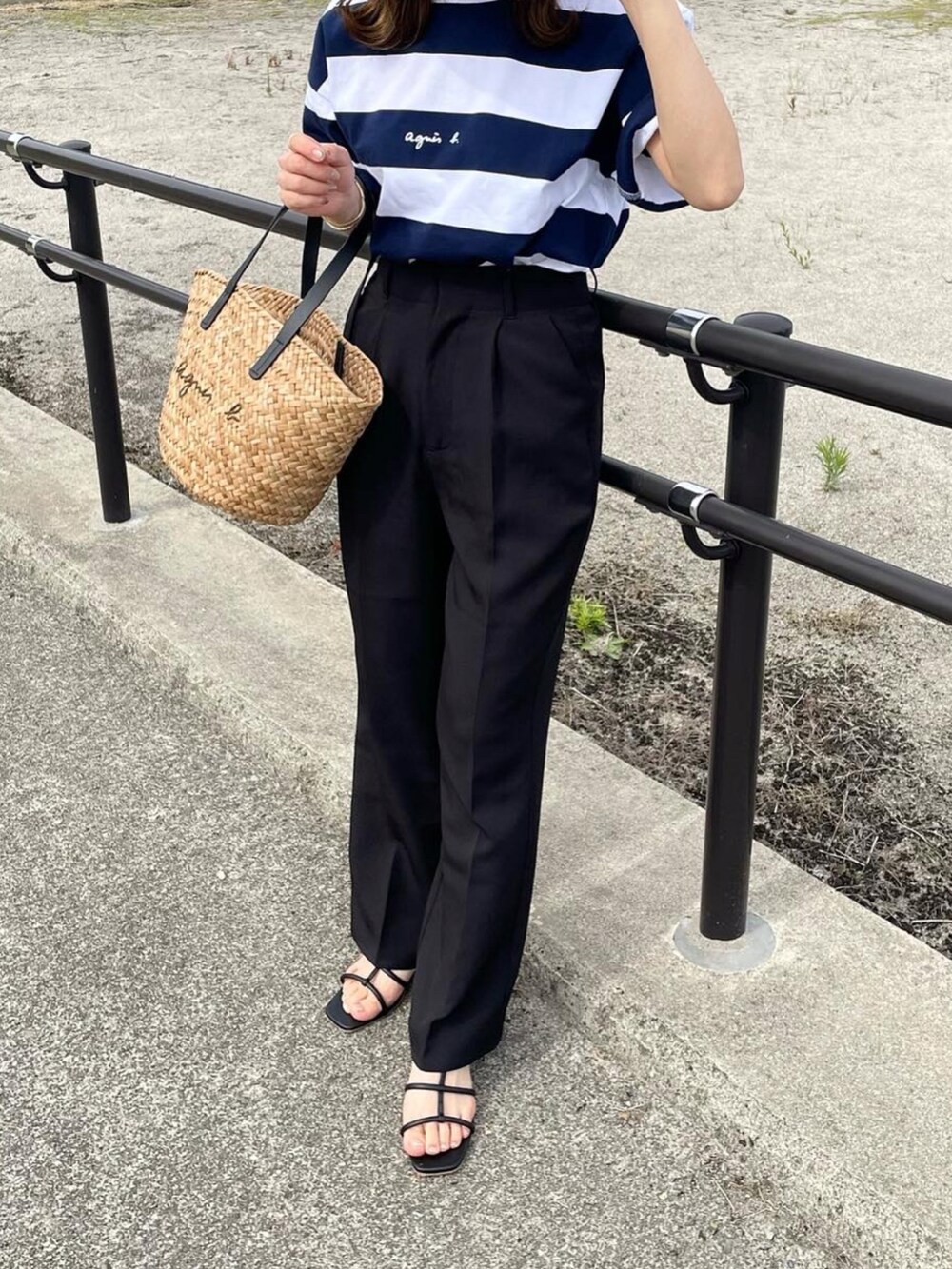 ブルー系のTシャツ/カットソー、ブラック系のスラックス、ブラック系のかごバッグを着用したレディースの夏コーディネートの4枚目の写真