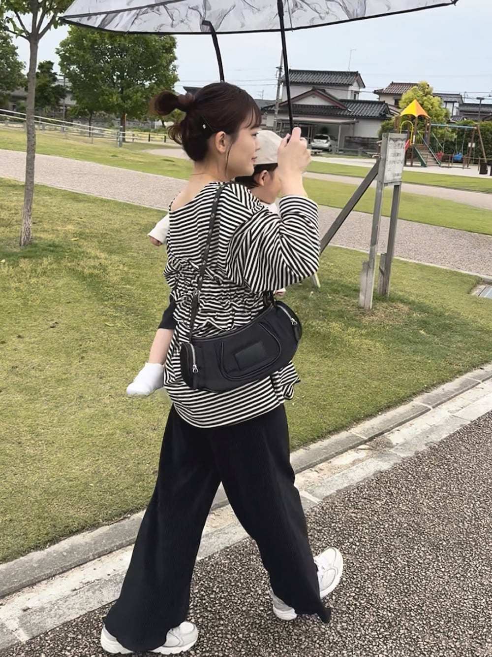 ブラック系のTシャツ/カットソー、ブラック系のその他パンツ、ホワイト系のスニーカーを着用したレディースの春コーディネートの3枚目の写真