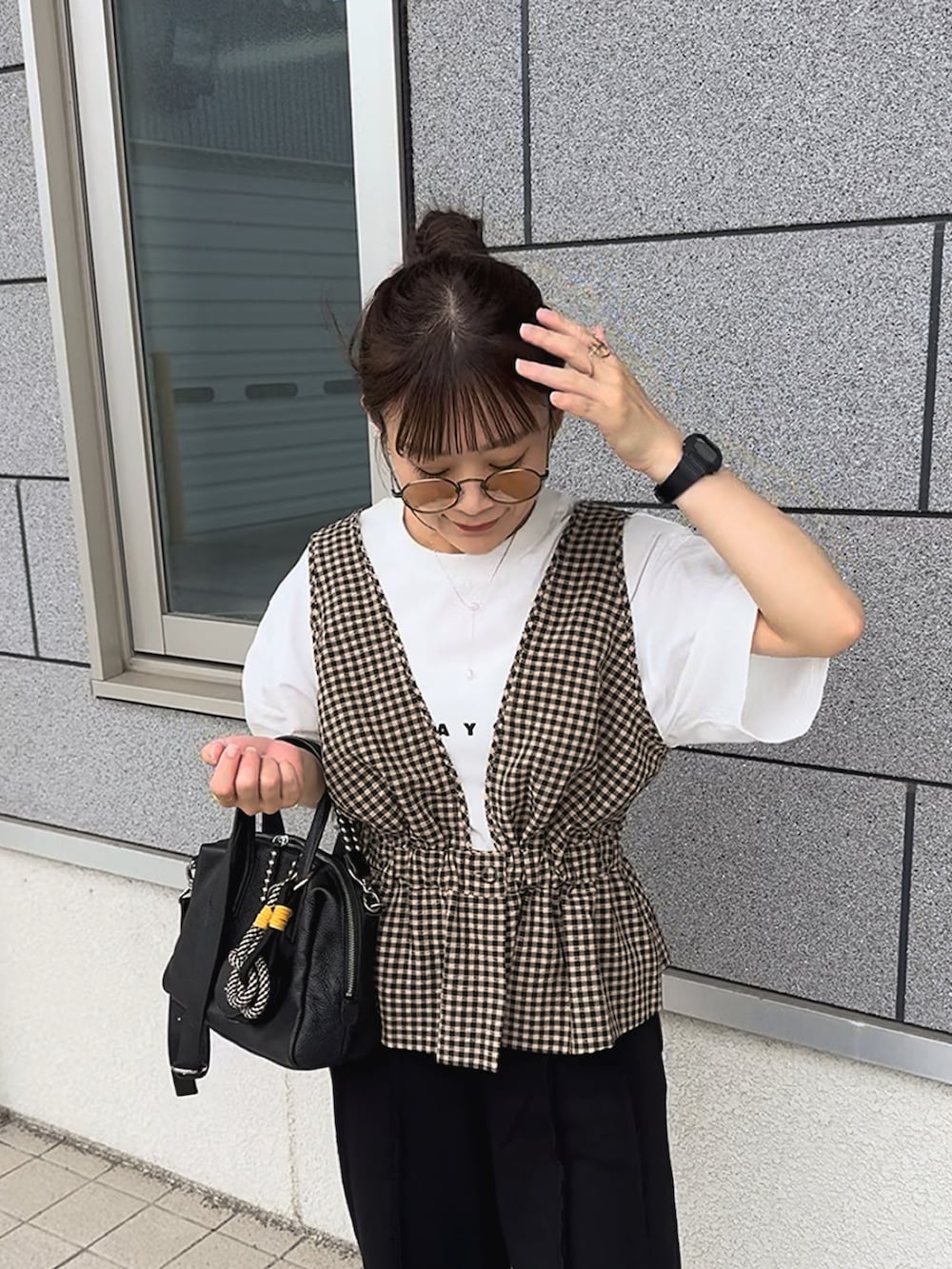 ブラック系のスウェットパンツ、ブラウン系のベスト、ホワイト系のTシャツ/カットソーを着用したレディースの夏コーディネートの5枚目の写真