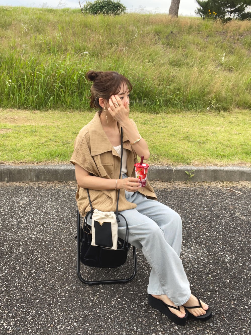 ブラウン系のシャツ/ブラウス、ブルー系のデニムパンツ、ホワイト系のショルダーバッグを着用したレディースの夏コーディネートの4枚目の写真