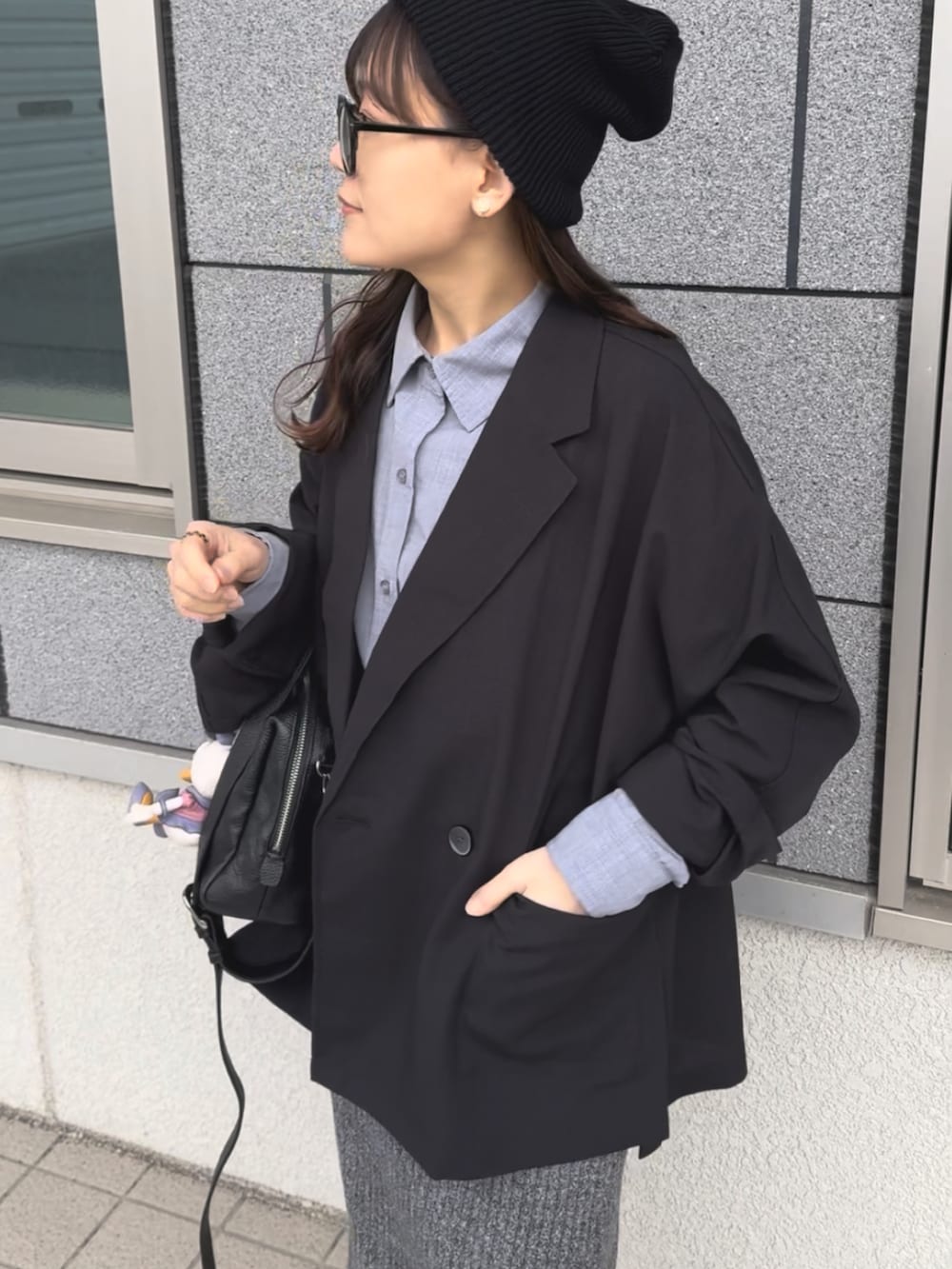 ブラック系のボストンバッグ、ブラック系のテーラードジャケット、ベージュ系のスニーカーを着用したレディースの春コーディネートの5枚目の写真