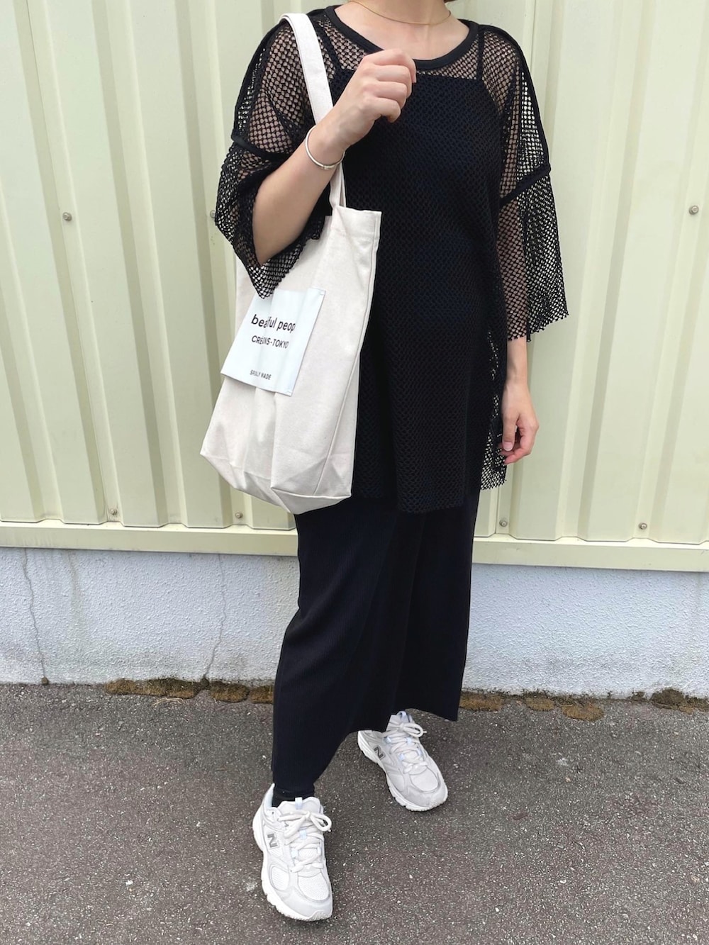 ブラック系のTシャツ/カットソー、ブラック系のワンピース、ホワイト系のトートバッグを着用したレディースの秋コーディネートの5枚目の写真