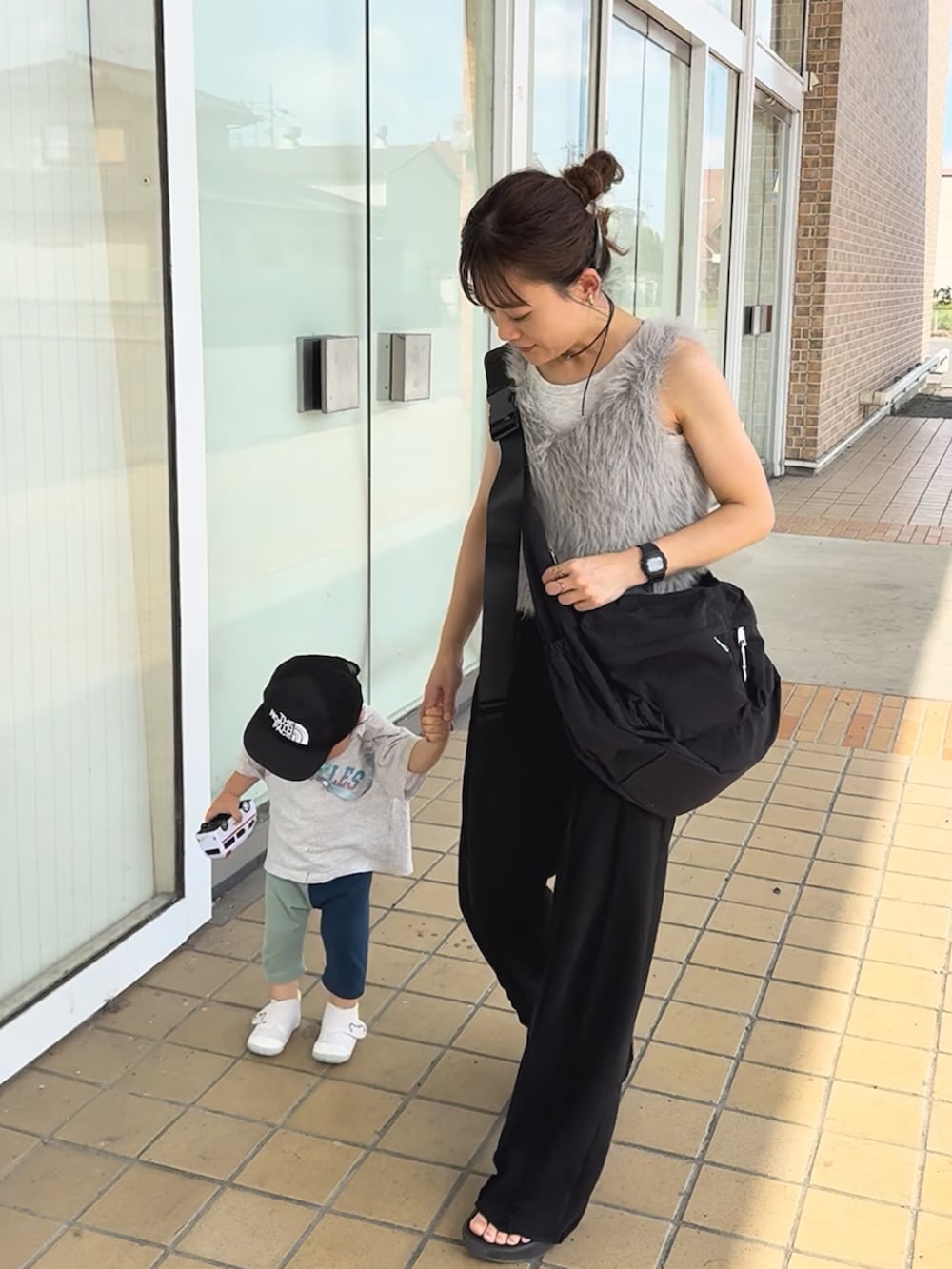 ブラック系のスウェットパンツ、ブラック系のサンダル、グレー系のベストを着用したレディースの夏コーディネートの2枚目の写真