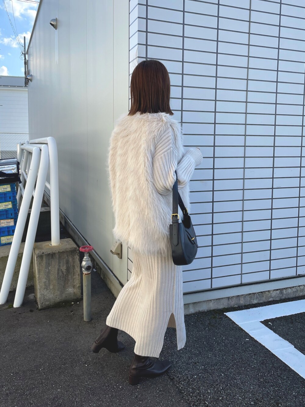 ホワイト系のベスト、ホワイト系のワンピース/ドレス、ブラック系のバッグを着用したレディースの秋コーディネートの4枚目の写真