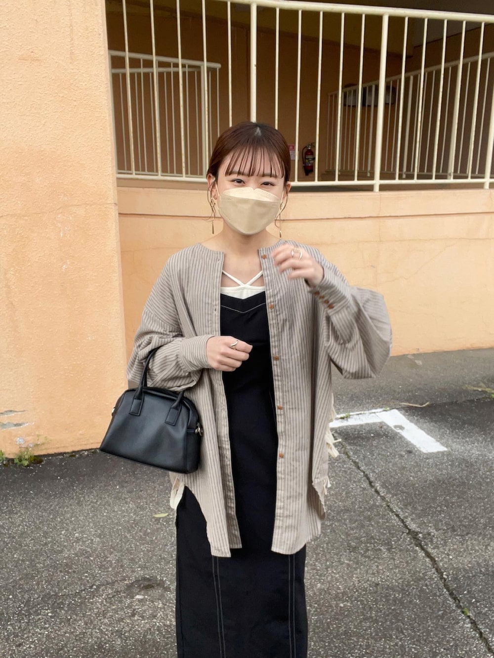 グレー系のシャツ/ブラウス、ブラック系のワンピース/ドレス、ホワイト系のキャミソールを着用したレディースの春コーディネートの5枚目の写真