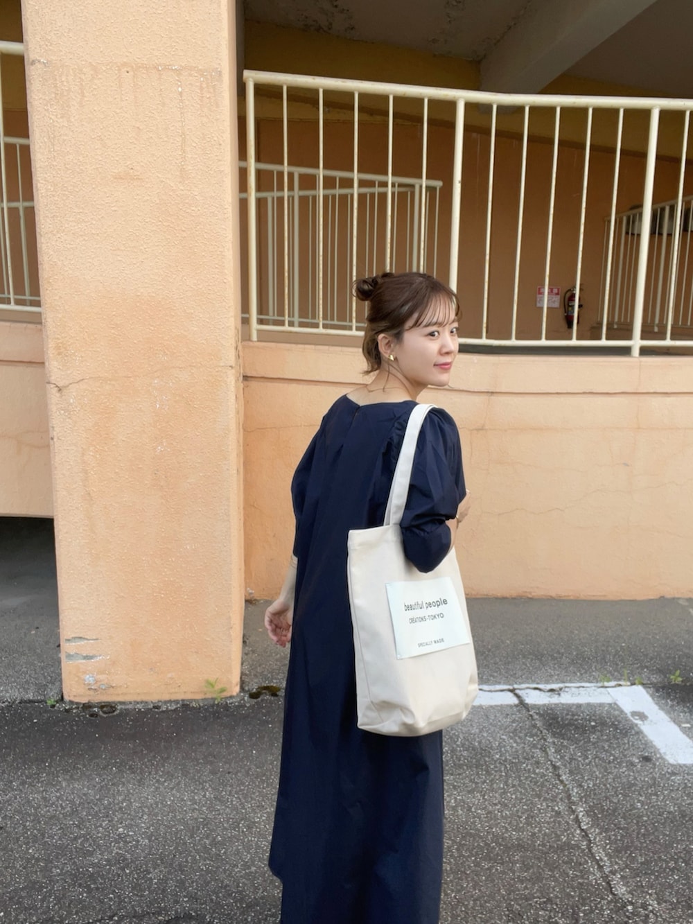 ブルー系のワンピース、ホワイト系のトートバッグ、ホワイト系のサンダルを着用したレディースの夏コーディネートの4枚目の写真