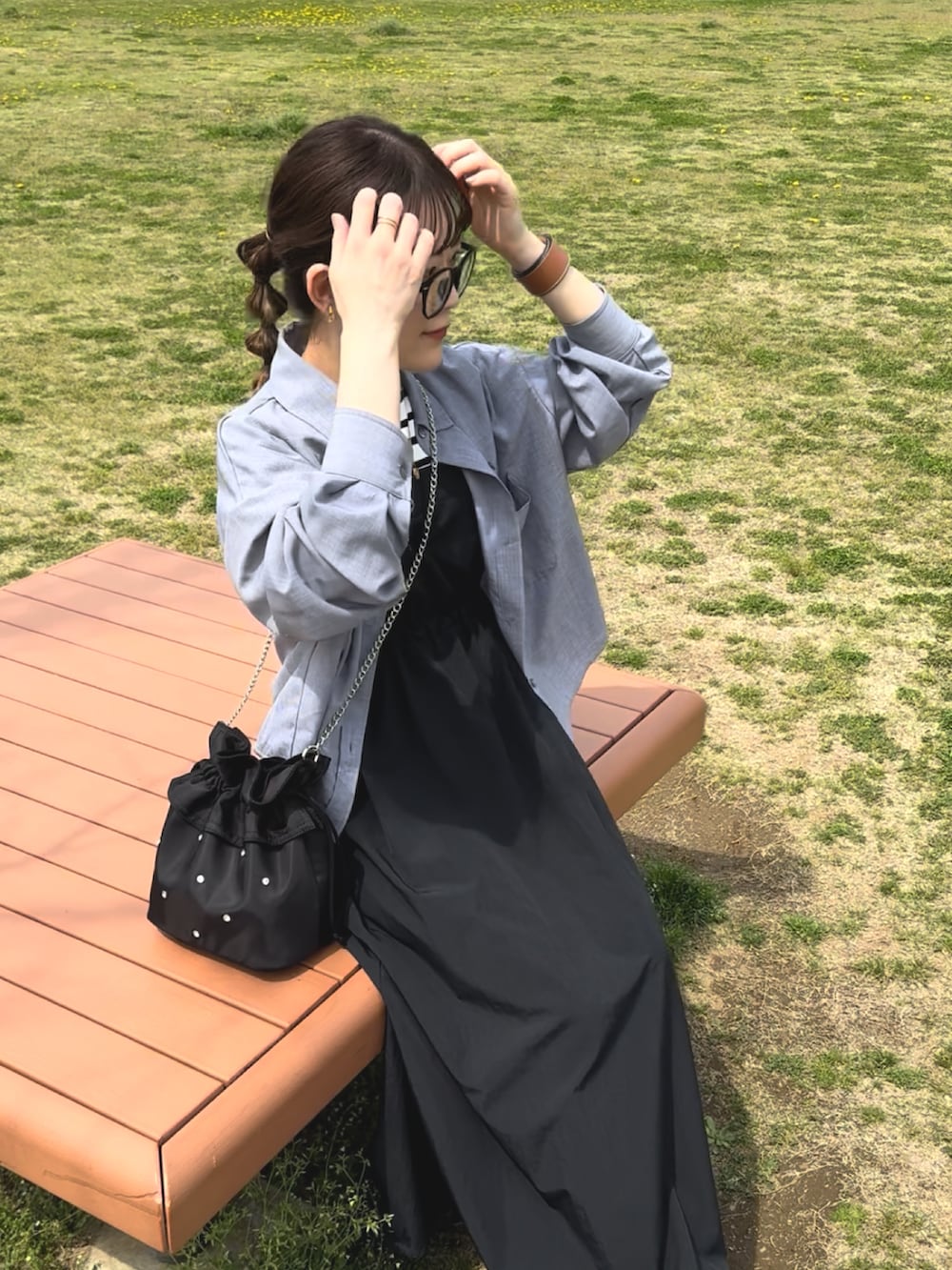 ブラック系のワンピース、ブルー系のシャツ/ブラウス、ホワイト系のスニーカーを着用したレディースの春コーディネートの5枚目の写真